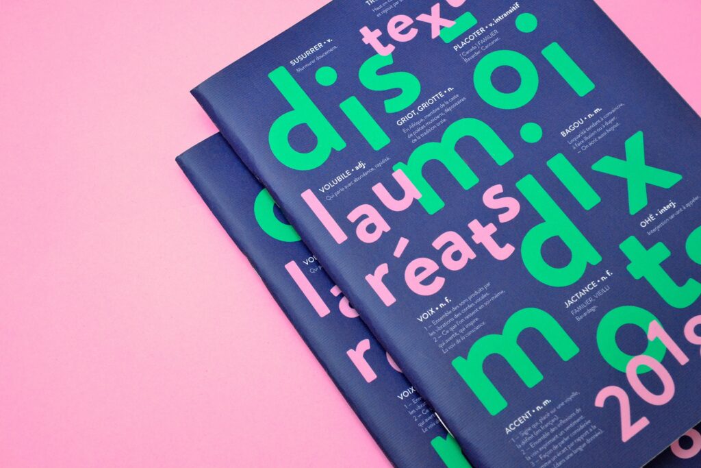 Couverture du livret "Dis-moi dix mots". Sur fond violet sombre e détachent le titre en vert vif et le sous-titre en rose vif. Les lettres s'entremêlent avec les définitions des dix mots du concours, écrites en blanc.